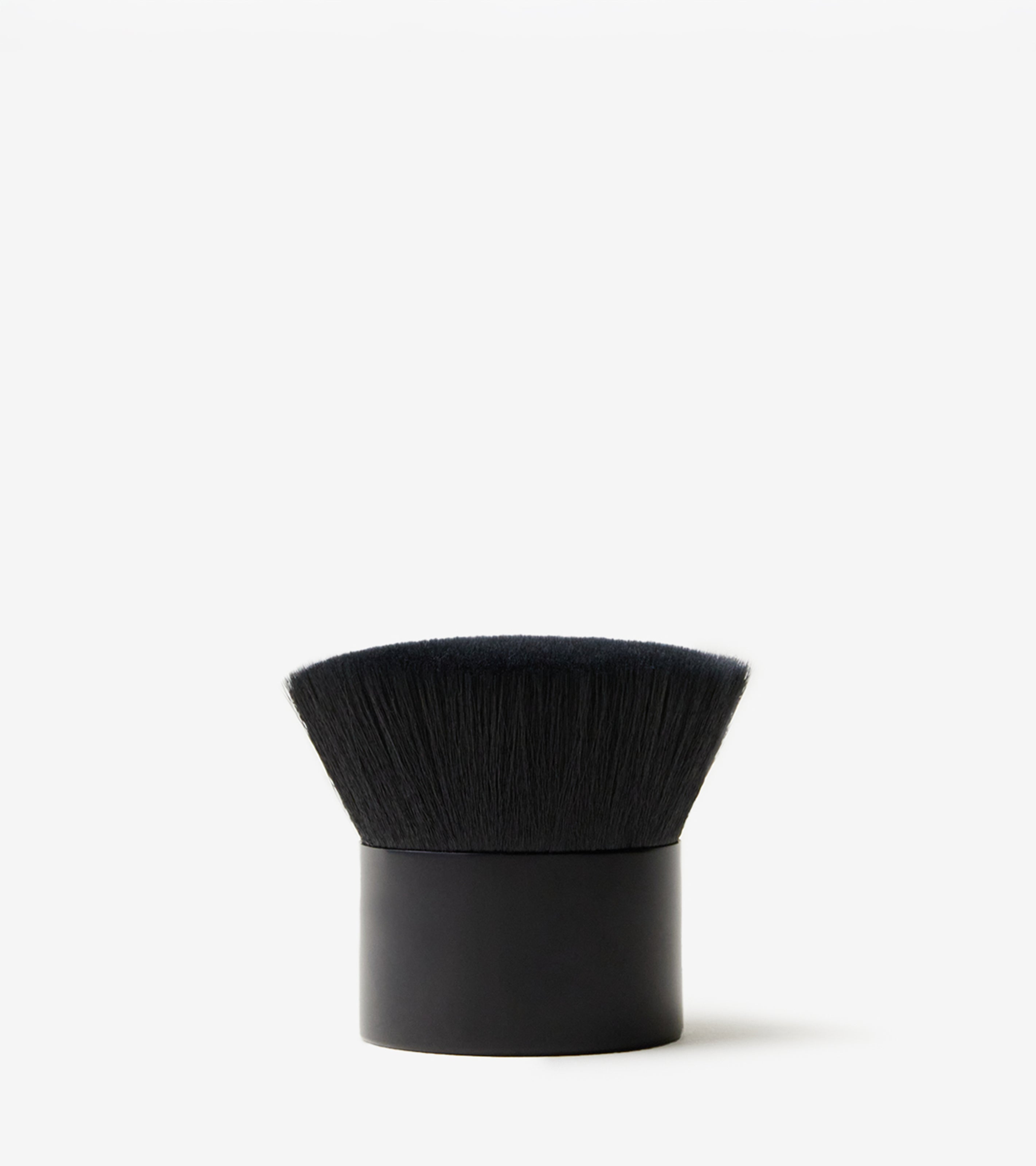 Brush No. 2, a flat-topped black blending brush with dense, soft bristles and a short cylindrical handle, stands upright against a plain white background—ideal for applying Tanning Foam for a streak-free finish.
