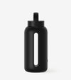 The Day Bottle is a black glass water bottle featuring a built-in lid handle and a vertical transparent window to show liquid levels, ideal for staying hydrated in summer, displayed on a plain white background.