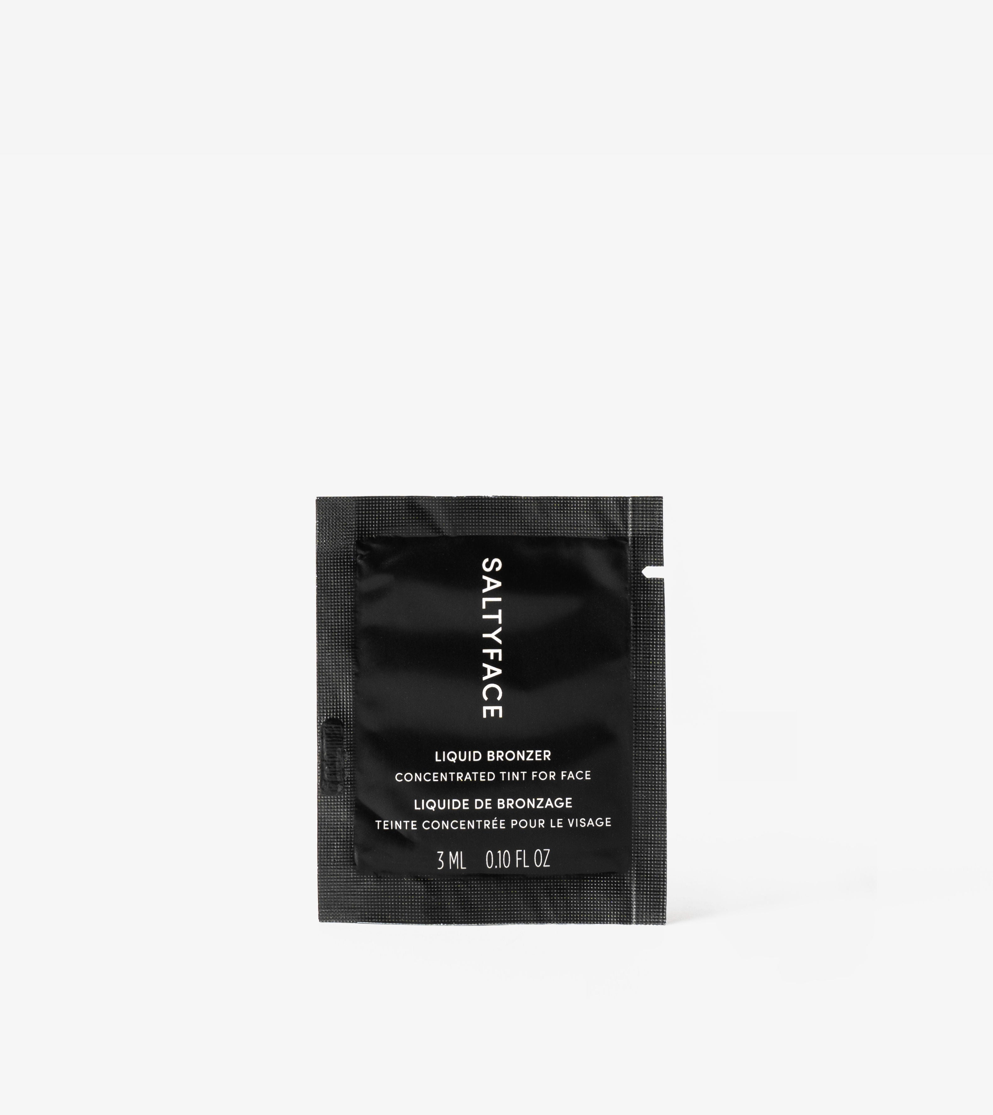 A small black packet labeled Liquid Bronzer Sample, 3 mL, 0.10 fl oz is centered on a plain white background.