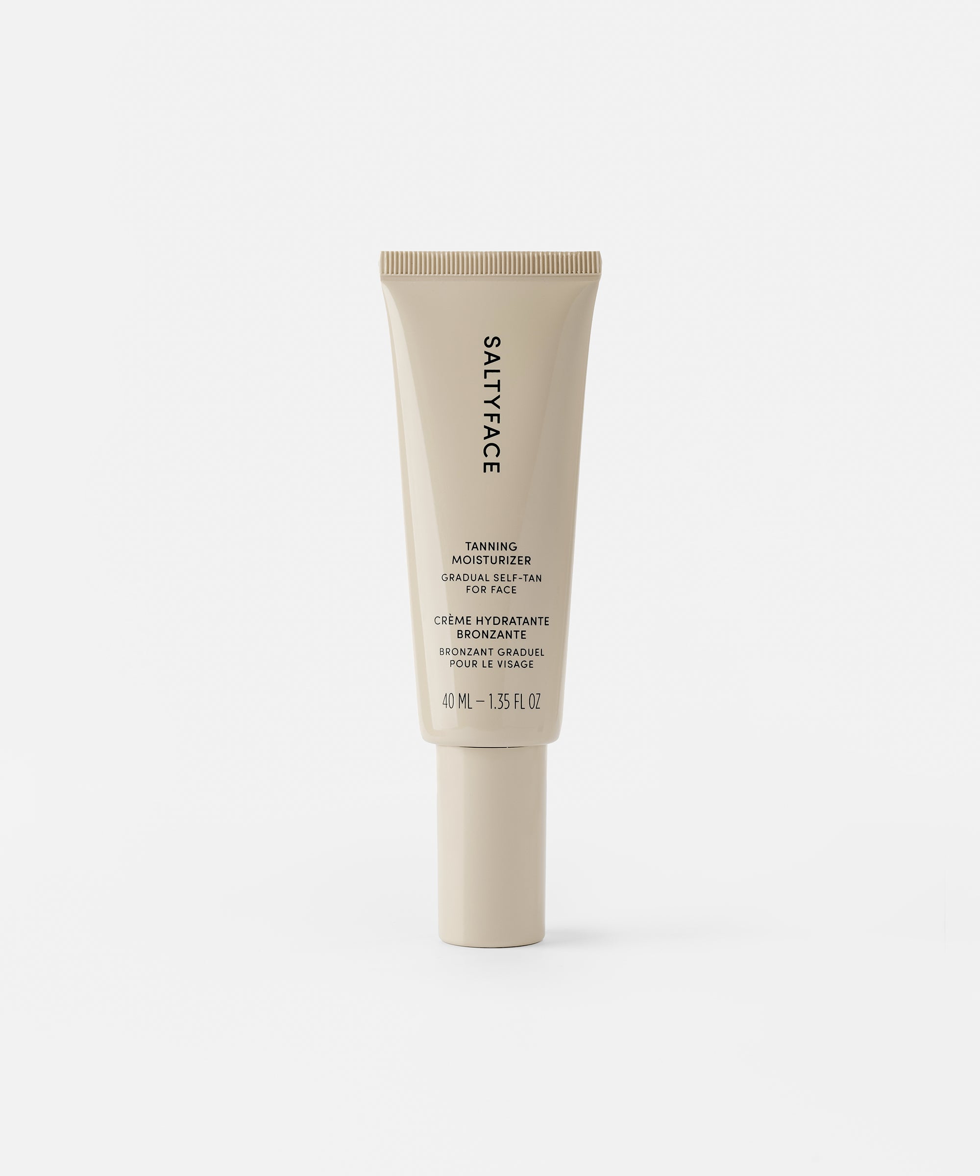 A beige tube of Tanning Moisturizer with a flip-top cap stands upright on a white background. Its label features black text, emphasizing a skincare-first formula for a natural, gradual tan.